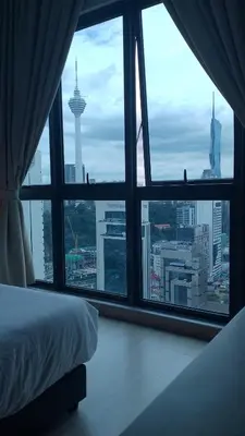 a bedroom with a view of a city from a window at The Colony Infinitum KLCC Suits By Sabu in Kuala Lumpur