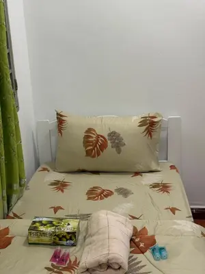 a bed with a pillow and a book on it at Happy Homes Kuala Lumpur Rooms in Kuala Lumpur