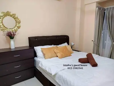 a bedroom with a bed with a dresser and a mirror at Izzafea in Ampang