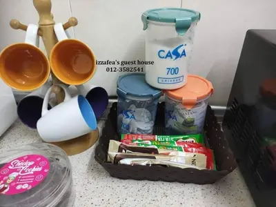 a kitchen counter with a container of food and utensils at Izzafea in Ampang