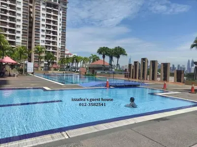 a large swimming pool with a person in the water at Izzafea in Ampang