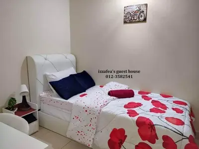 a bedroom with a bed with red flowers on it at Izzafea in Ampang
