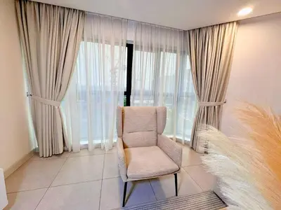 a living room with a chair and large windows at Premium Executive Family Suites 3Bedroom at The Atrium Ampang by OKBnB in Kuala Lumpur