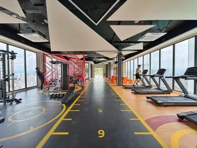 a gym with treadmills and people in a building at Majestic Unique Studio Suite with Infinity Pool in Kuala Lumpur