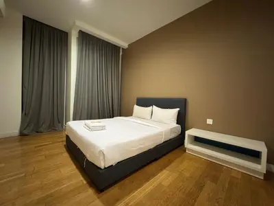 a bedroom with a large bed with white sheets at White stone suites in Kuala Lumpur