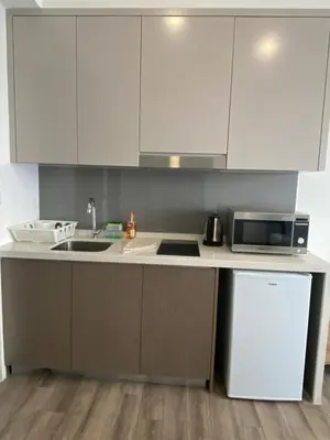 a kitchen with white cabinets and a sink and a microwave at Agile Bukit Bintang Save Home in Kuala Lumpur