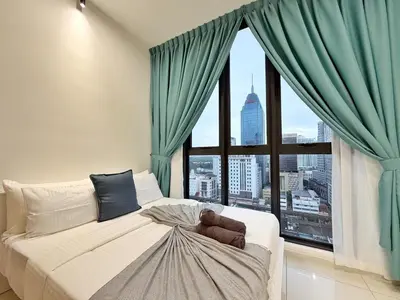 a bed with a teddy bear sitting on it in front of a window at Majestic Wonder Studio Suite with Infinity Pool in Kuala Lumpur