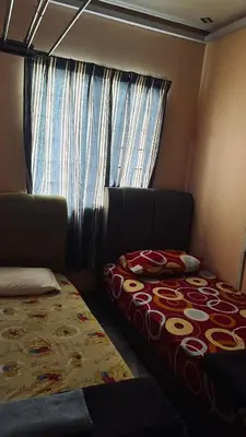 a small room with a bed and a window at Homestay in Kuala Lumpur