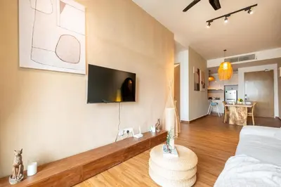 a living room with a couch and a tv on the wall at Legasi Residence By Feel Home in Kuala Lumpur