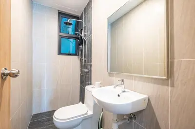 a bathroom with a sink and a toilet and a mirror at Legasi Residence By Feel Home in Kuala Lumpur