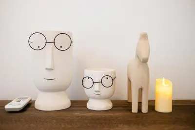 a table with two manikins wearing glasses and a candle at Legasi Residence By Feel Home in Kuala Lumpur