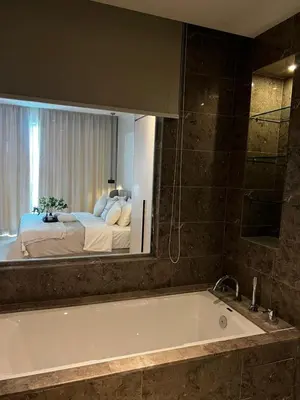 a bathroom with a tub and a bed in a mirror at Modern Studio Escape in Kuala Lumpur