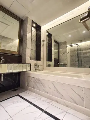 a bathroom with a tub and a large mirror at Cozy Studio Retreat in Kuala Lumpur