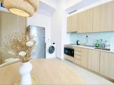 a kitchen with a vase of flowers on a table at The Colony Infinitum by Manila in Kuala Lumpur