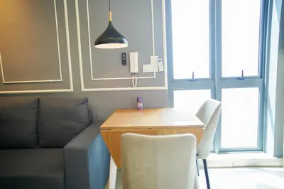 a living room with a table and chairs and a couch at The Colony Infinitum by Manila in Kuala Lumpur