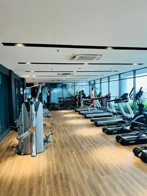 a gym with a row of treadmills and machines at The Colony by Klcc Wisma Infinitum in Kuala Lumpur