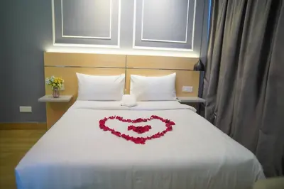 a heart made out of flowers on a bed at The Colony by Klcc Wisma Infinitum in Kuala Lumpur
