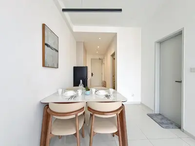 a dining room with a white table and two stools at Majestic Calm 1BR Suite with Rooftop Infinity Pool in Kuala Lumpur