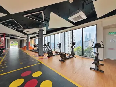 a gym with tread machines and a large window at Majestic Calm 1BR Suite with Rooftop Infinity Pool in Kuala Lumpur