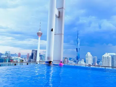 a couple in a pool on the roof of a building at THE Colony KL at Sky World in Kuala Lumpur