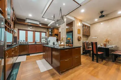 a large kitchen with wooden cabinets and a dining room at Provence Chateau Retreat 40 Pax Pool Villa Bangsar by Verano in Kuala Lumpur