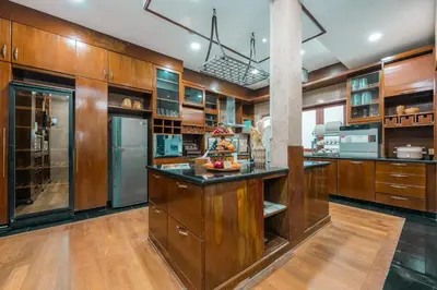 a large kitchen with wooden cabinets and a island at Provence Chateau Retreat 40 Pax Pool Villa Bangsar by Verano in Kuala Lumpur