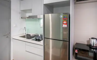 a stainless steel refrigerator in a kitchen with a sink at Riveria Sky Residences KL Sentral with Infinity Pool in Kuala Lumpur