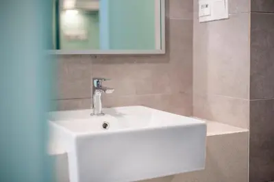 a bathroom with a white sink and a mirror at Riveria Sky Residences KL Sentral with Infinity Pool in Kuala Lumpur