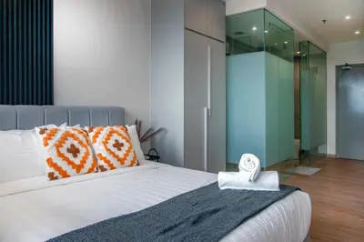 a bedroom with a large bed with a glass wall at Riveria Sky Residences KL Sentral with Infinity Pool in Kuala Lumpur