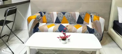 a white table and a couch with pillows on it at Summer suite KLCC by Classic Stay in Kuala Lumpur