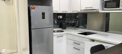 a kitchen with a stainless steel refrigerator and white cabinets at Summer suite KLCC by Classic Stay in Kuala Lumpur