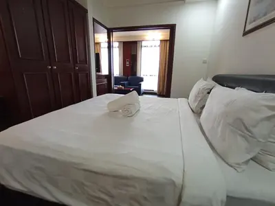 a white bed with a towel on top of it at Maritime Residence at Times Square KL in Kuala Lumpur