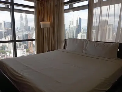 a bedroom with a white bed and a large window at Maritime Residence at Times Square KL in Kuala Lumpur