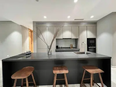 a kitchen with two stools and a counter with a sink at Apartment Sixceylon City Centre in Kuala Lumpur