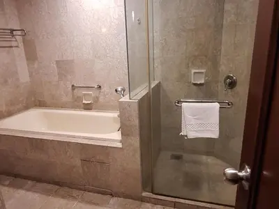 a bathroom with a tub and a shower with a towel at Time square luxury suites in Kuala Lumpur