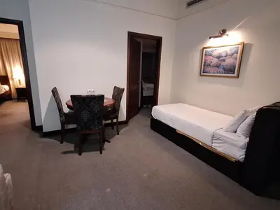 a bedroom with a bed and a table and chairs at Time square luxury suites in Kuala Lumpur