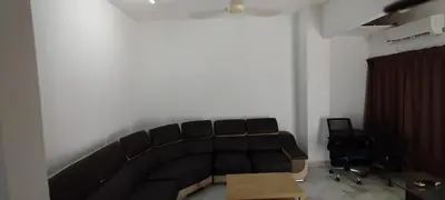a living room with a black couch and a table at Segambut Homestay MITEC KLCC PWTC town center in Kuala Lumpur
