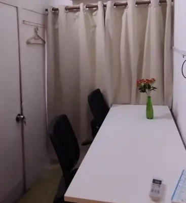 a table with two chairs and a vase of flowers on it at Segambut Homestay MITEC KLCC PWTC town center in Kuala Lumpur