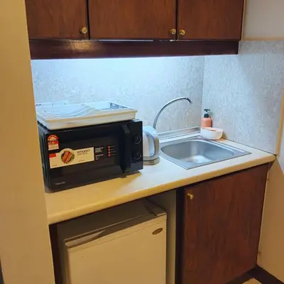 a microwave sitting on a kitchen counter next to a sink at Home land apartment by Times Square in Kuala Lumpur