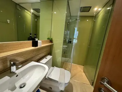 a bathroom with a sink and a glass shower at Tomato Homestay in Kuala Lumpur