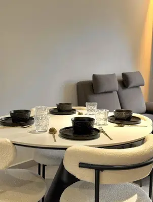 a table with plates and bowls on it with a couch at Friendly & Cozy Near TRX & Pavilion in Kuala Lumpur