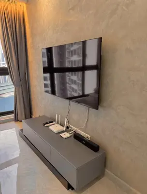 a living room with a tv on a wall at Friendly & Cozy Near TRX & Pavilion in Kuala Lumpur