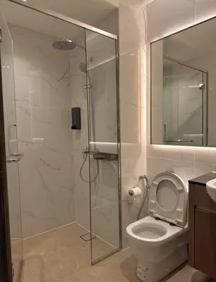 a bathroom with a toilet and a glass shower at Friendly & Cozy Near TRX & Pavilion in Kuala Lumpur