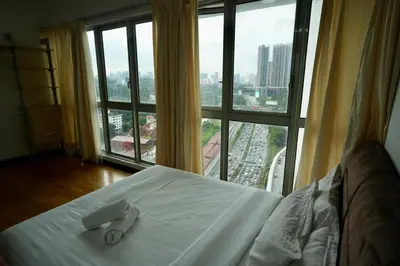 a bed in a room with a large window at Willow Home in Kuala Lumpur