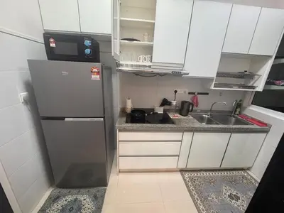 a small kitchen with a refrigerator and a sink at Desa green unit in Kuala Lumpur