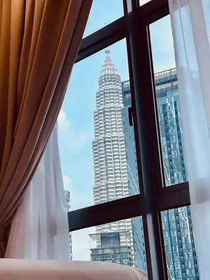 a window with a view of a tall building at Royce Residence KLCC twin tower by ABM Unique in Kuala Lumpur