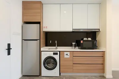a kitchen with a washing machine and a refrigerator at Royce Residence KLCC twin tower by ABM Unique in Kuala Lumpur