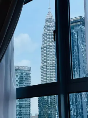 a view of a tall building from a window at Royce Residence KLCC twin tower by ABM Unique in Kuala Lumpur