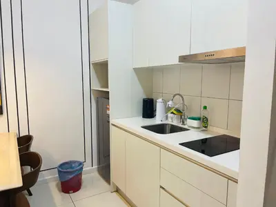 a small kitchen with white cabinets and a sink at Chambers suites KLCC by Infinity in Kuala Lumpur