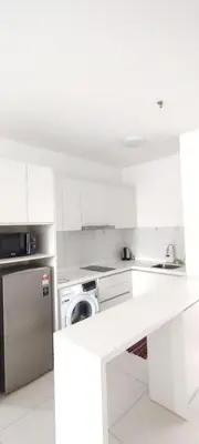 a white kitchen with a washer and a dishwasher at Chambers suites KLCC by Infinity in Kuala Lumpur